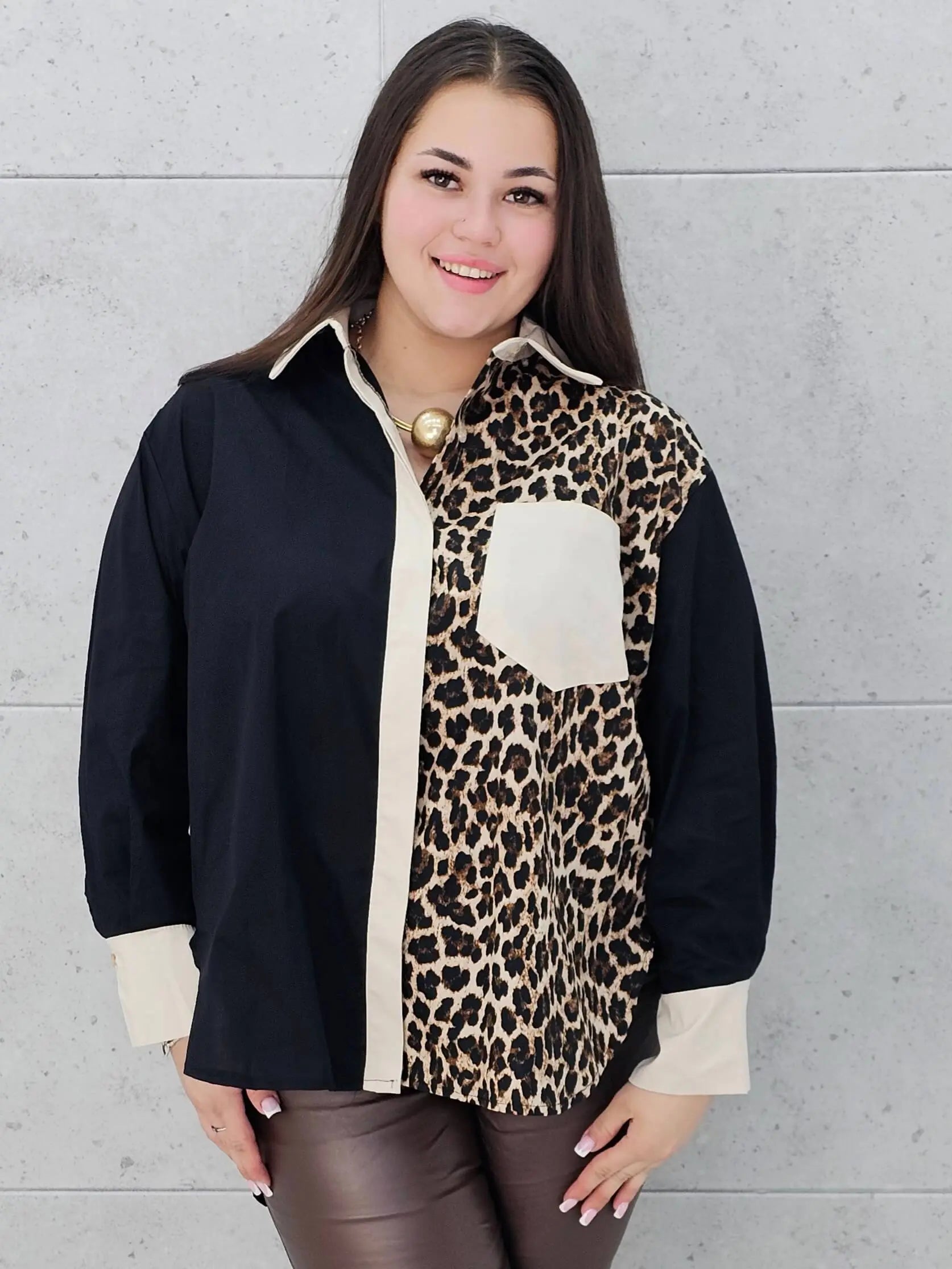 Kobieta w koszuli plus size z motywem panterki, czerni i beżu, prezentuje elegancką stylizację z kolekcji Stylowa XL. Modna koszula w stylu casualowym i eleganckim dla kobiet w rozmiarze XL.