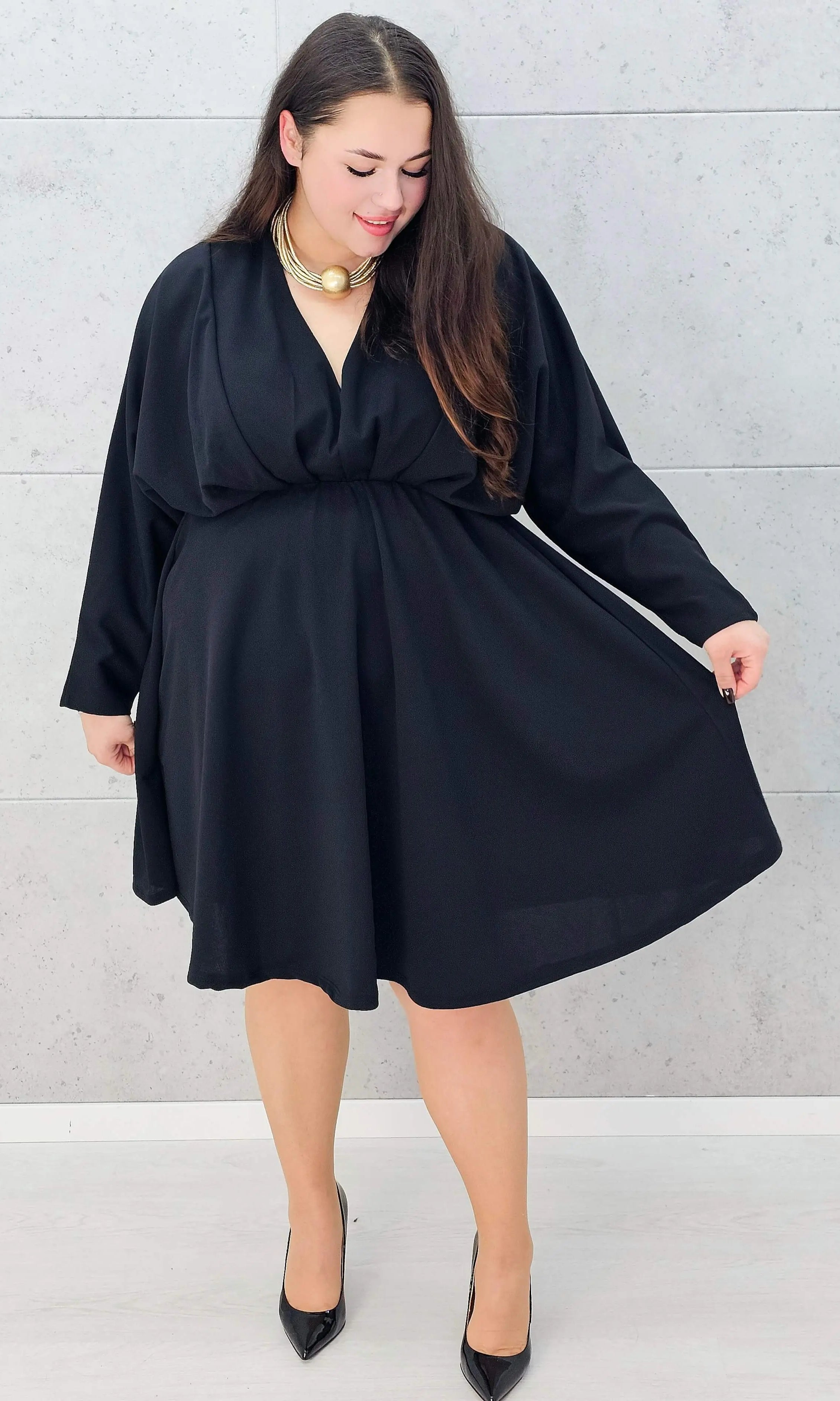 Czarna rozkloszowana sukienka plus size na wesele lub kolację - przodem z pokazaniem litry A