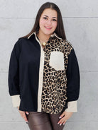 Kobieta w koszuli plus size z motywem panterki, czerni i beżu, prezentuje elegancką stylizację z kolekcji Stylowa XL. Modna koszula w stylu casualowym i eleganckim dla kobiet w rozmiarze XL.